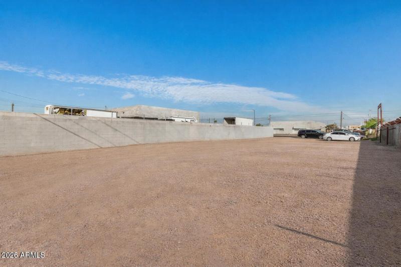 Empty dirt lot with fences and trucks (2