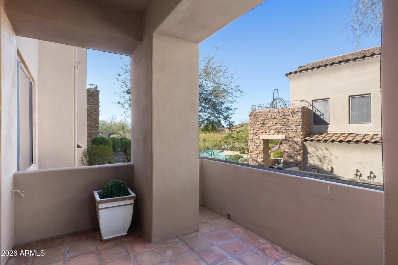 One of two tiled patios with pool & suns