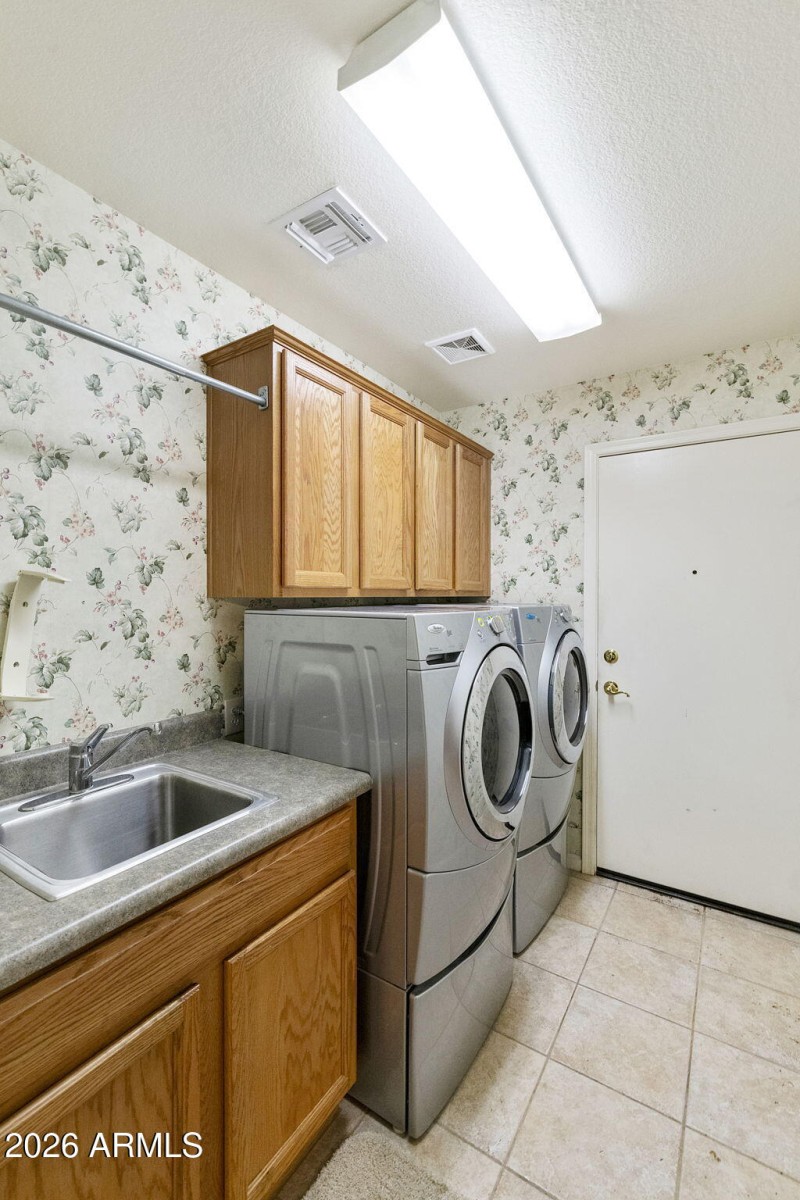 Laundry room with sink and cabinets
