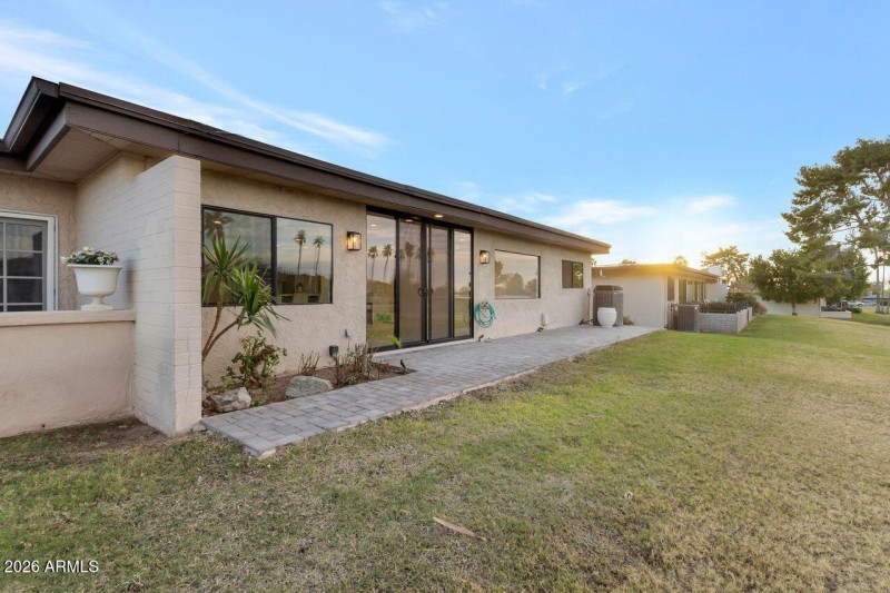 Rear patio opens to generous grounds.