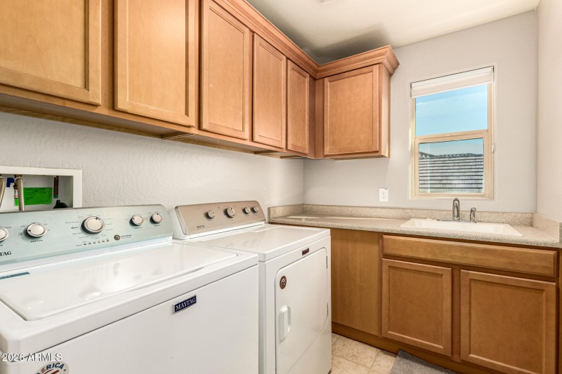 Laundry with cabinets and sink