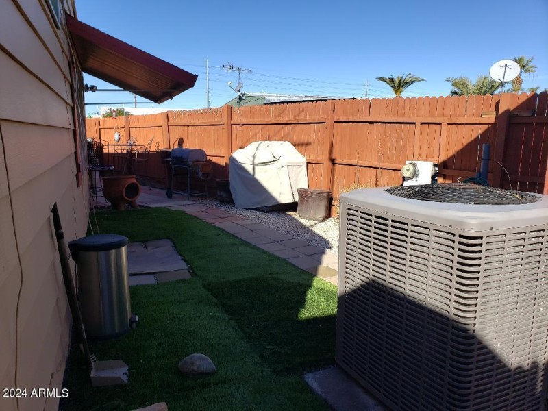 Yard with artificial turf and ac unit