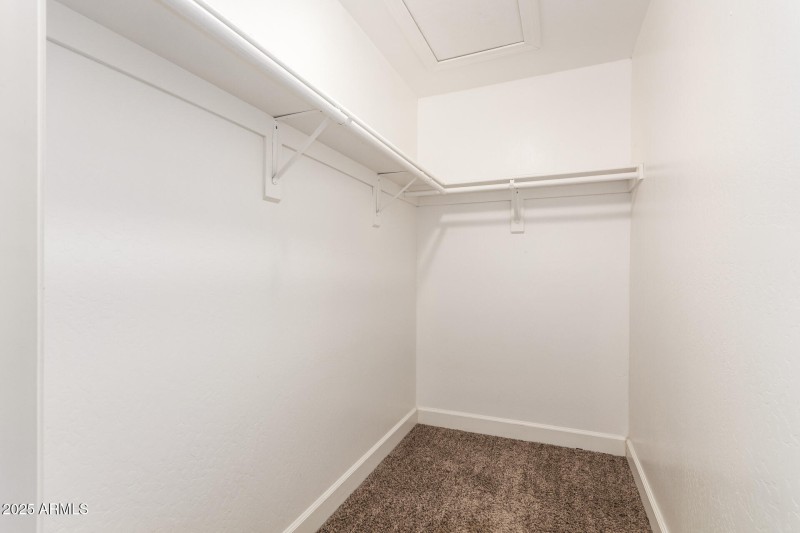 Primary bedroom walk in closet