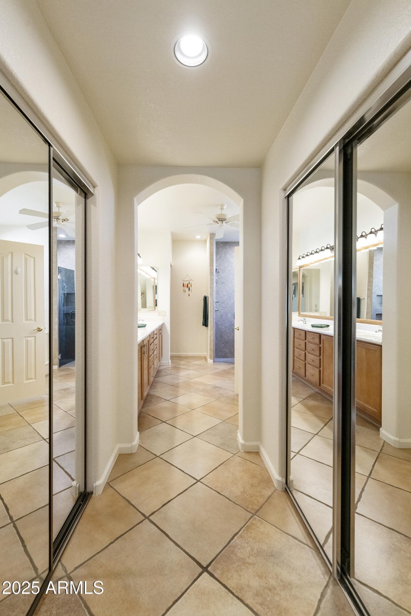 Primary suite closets outside bathroom