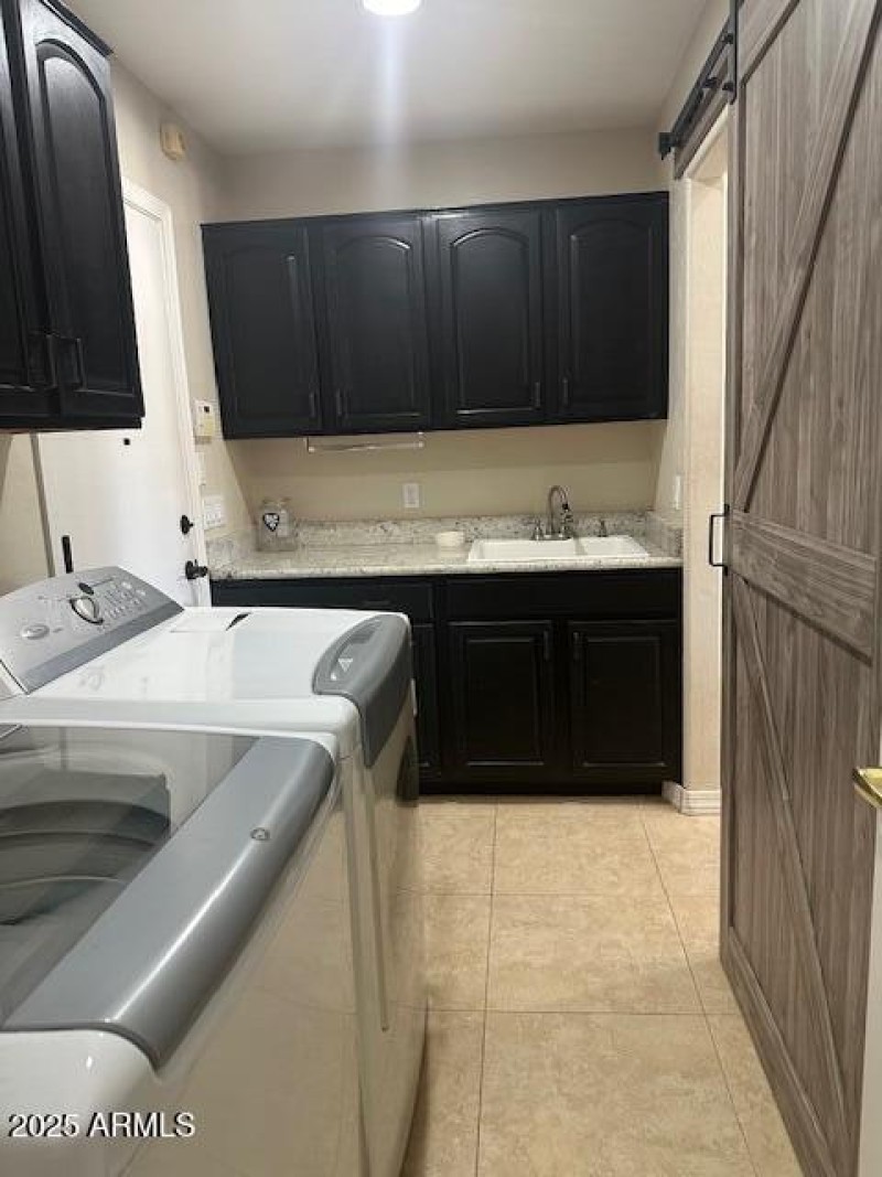 Laundry room has sink and cabinets