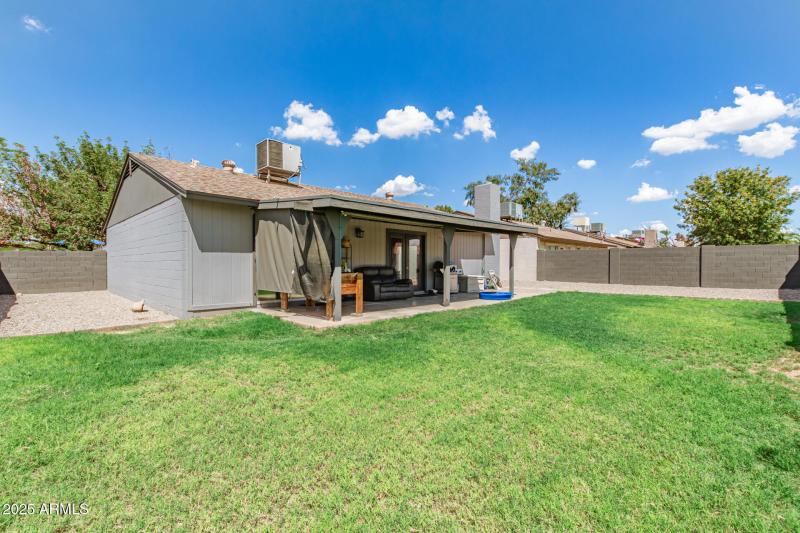 Large grass area with covered patio