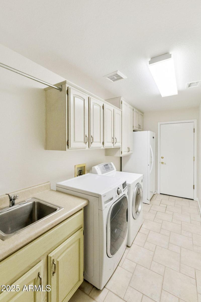 Laundry with cabinets and sink
