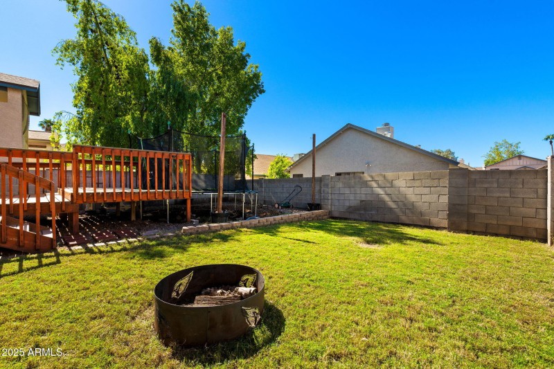 Large backyard with deck and trampoline