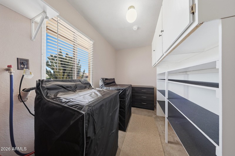 Laundry with cabinets and shelving