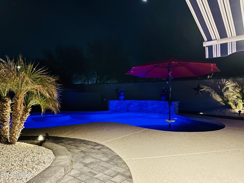 Night shot of the backyard and pool