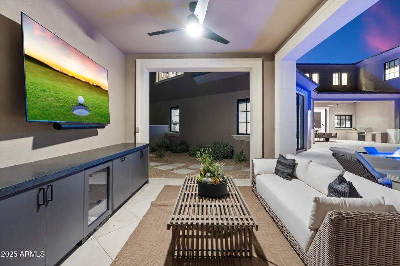 Cabana in backyard with TV and bar