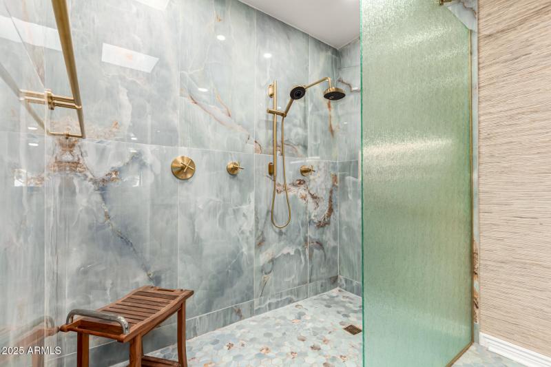 Master shower with gold fixtures