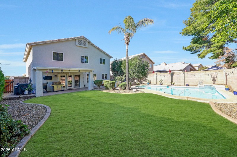 Grassy backyard oasis with pool