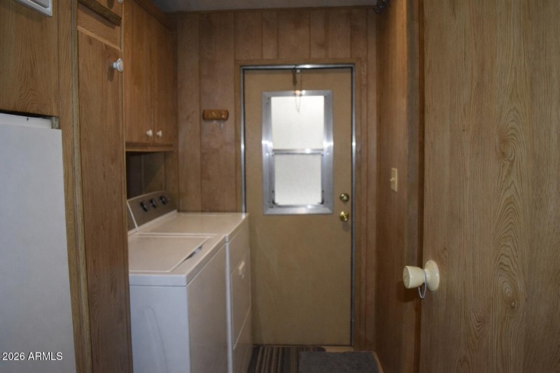 Laundry room with wood paneling