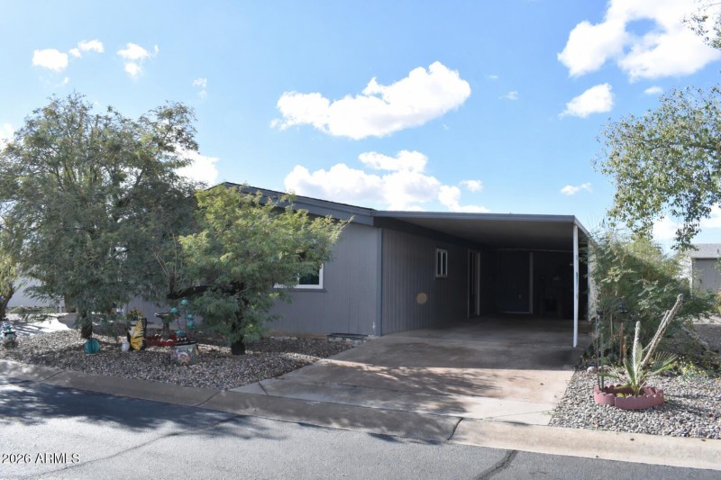 Gray home with carport and garden